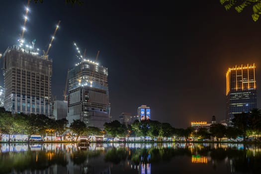 Bangkok, Thailand - Dec 8, 2022:Waterfront view of Lumpini Park at night on the day of the Red Cross Fair Causing there to be lights along the riverside path beautiful atmosphere Between 8-18 Dec 2022
