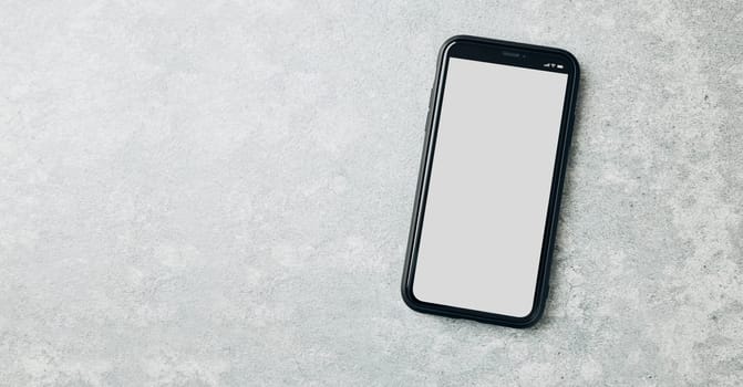 Smartphone mockup with solid white color blank empty isolated screen on marble background. Black mobile phone top view flat lay with copy space. Ready for content. Room for text