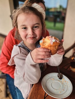 Girl enjoying eating sweet tasty cupcake that you she made herself at home