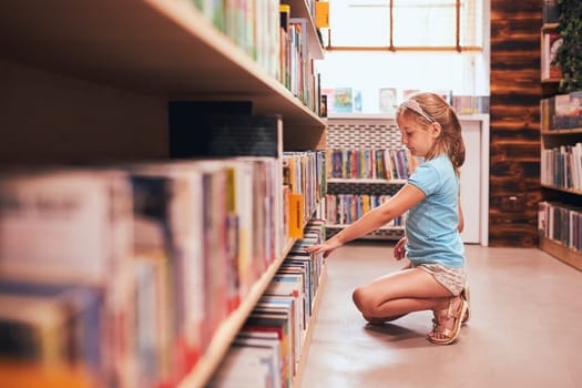 Schoolgirl looking for book for reading in school library. Student choosing literature for reading. Books on shelves in bookstore. Learning from books. Back to school. Elementary education. Doing homework