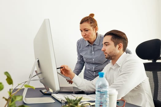 Business colleagues discussing financial data working together in office. People entrepreneurs working with charts and tables on computer. Two people working together. Workmates talking about project