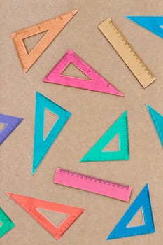 Arranged colorful set squares on brown paper