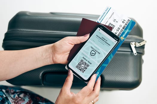 Digital covid certificate. Covid negative rapid digital test pass. Woman passenger holding digital medical pass on her mobile phone, passport and airplane ticket. Traveler showing digital covid test result as medical pass for travel during covid-19 pandemic