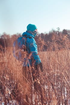 Boy hiking through meadows in the wintertime