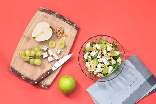 Making salad with grapes, pear, walnut and blue cheese