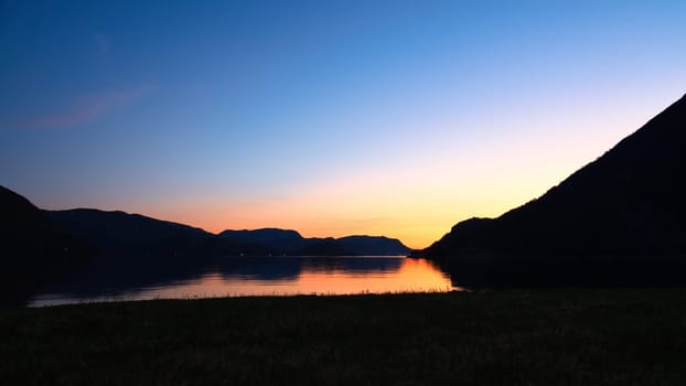 Fjord with view of mountains and fjord landscape in Norway. Landscape shot in the evening in the north with bright sky.