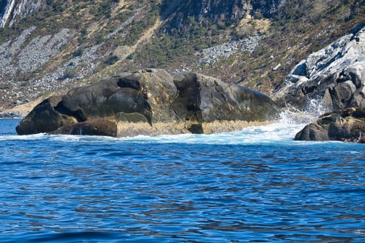 norway on the fjord, spray on rocks. Water splashes on the stones. Coastal landscape in Scandinavia. Landscape photo from the north