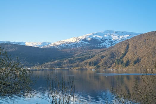 Nordfjord in Norway. View of mountains covered with snow. Wilderness in Scandinavia, in sunshine. Landscape photo from the north