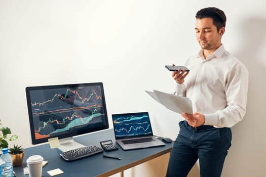 Businessman trading stocks online. Stock investor discussing numbers at graphs while phone conversation with his colleague. Business team planning and analyzing stock market graphs. Man working with stock chart data. Business man investing stock using online platform. Business success concept