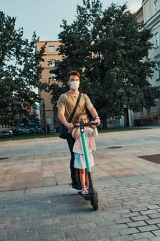 Young man and her sister preschooler riding an electric scooter in the city center. Man wearing the face mask to avoid virus infection and to prevent the spread of disease in time of coronavirus. Candid people, real moments, authentic situation