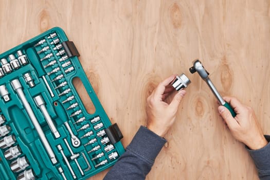 Man working in workshop using many tools. Wrench, spanner, calliper and ratchet with many attachments. Work tools. Universal tool set. Professional equipment