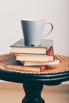A few books with cup of coffee on chair