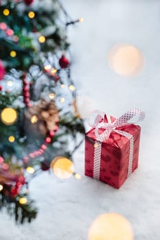 Christmas gift put on the snow under a tree outdoor