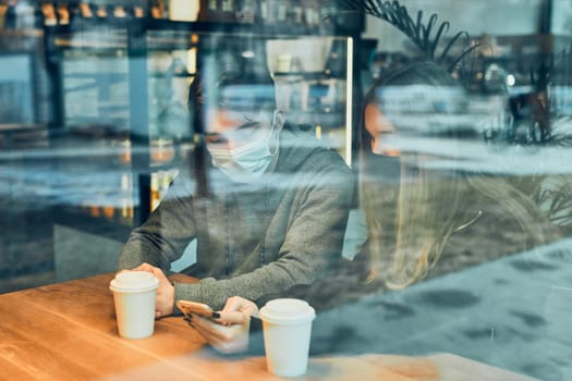 Friends having a chat, talking together, drinking coffee, sitting in a cafe. Young man and woman relaxing in cafe, having a break
