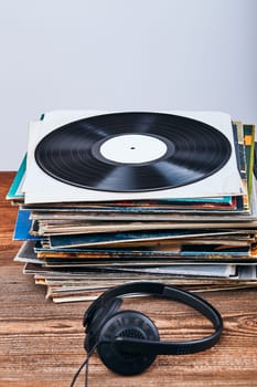 Stack of black vinyl records and headphones on the top. Candid people, real moments, authentic situations