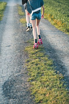 Teenage girls having fun rollerskating, spending time together on summer day