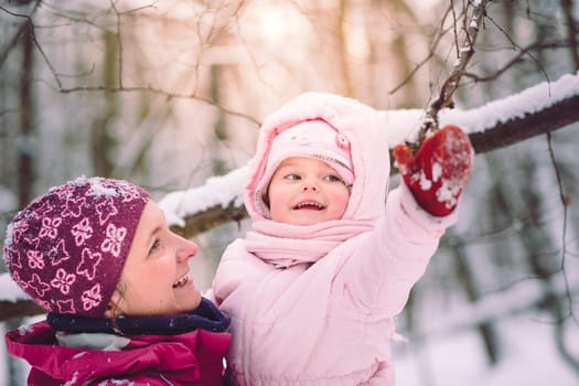 Mother spending time with her little daughter outdoors in the wintertime