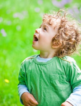 The portrait of a 1 and a half year old baby boy enjoying the outdoors.