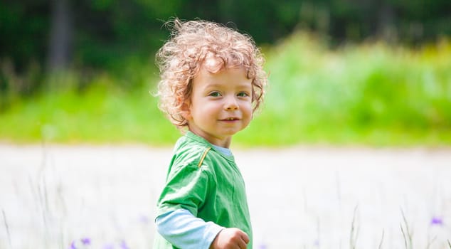 The portrait of a 1 and a half year old baby boy enjoying the outdoors.