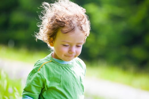 The portrait of a 1 and a half year old baby boy enjoying the outdoors.