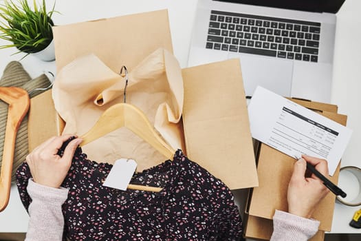 Business owner packing online order to delivery to customer. Preparing parcel box with clothes product from online shop