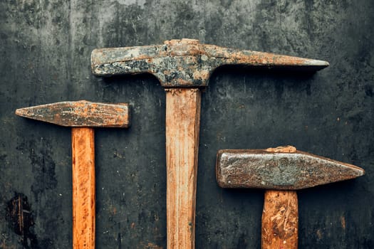Old hammers on steel surface. Rusty tools for maintenance. Hardware tools to fix. Technical background with copy space