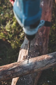 Drilling hole in timber while working in garden