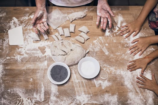 Hands kneading dough. People making dough for bread during bread making workshop. Flour and raw dough on wooden table