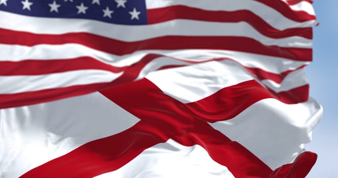 United States and Alabama flags waving together on a sunny day. The flag of Alabama features a red cross on a white field. 3d illustration render. Selective focus, Fluttering fabric.