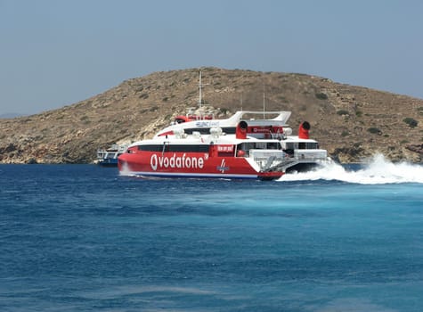 ISLAND OF IOS, CYCLADES, GREECE - JULY 16, 2006: Hellenic Seaways passenger catamaran Flying Cat 4 leaving the port bay of Ios island