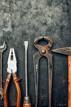 Old hardware tools. Wrench, screwdriver, measure, hammer, pliers on steel surface. Mechanic tools for maintenance. Hardware tools to fix. Technical background with copy space