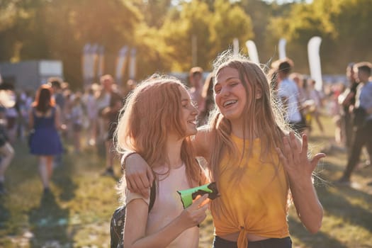 Portrait of happy smiling young girls with colorful paints on faces and clothes. Two friends spending time on holi color festival