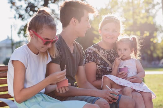 Family spending time together in the city centre eating ice cream on a summer day