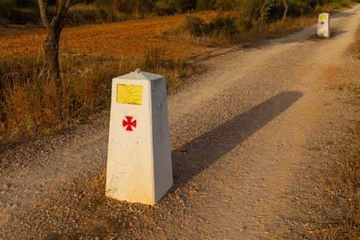 Navarre, Spain, 26 August, 2022: Yellow scallop shell, touristic symbol of the Camino de Santiago showing direction on Camino Norte in Spain. Column signing the way to Santiago De Compostela on the St James pilgrimage route.