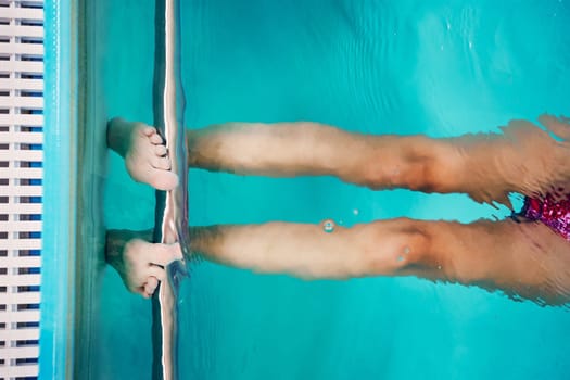 Young woman swimming and relaxing in swimming pool. Candid people, real moments, authentic situations