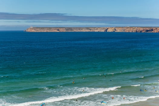 Sagres, Portugal - August 25, 2022: View of surfers on sandy beach near Sagres village in Algarve, Portugal