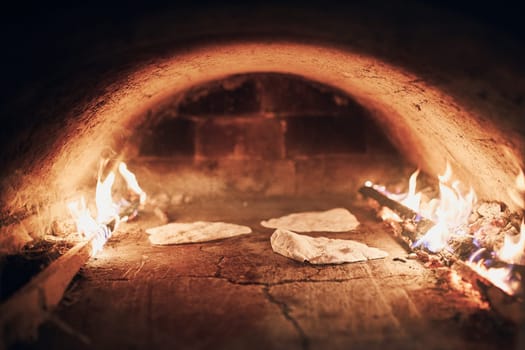 Flatbread in wood oven. Baking bread in traditional wood oven