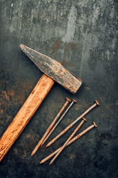 Hammer and nails on steel surface. Tools for maintenance. Hardware tools to fix. Technical background with copy space