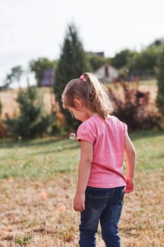 Little girl playing with soap bubbles outdoors on summer day. Real people, authentic situations