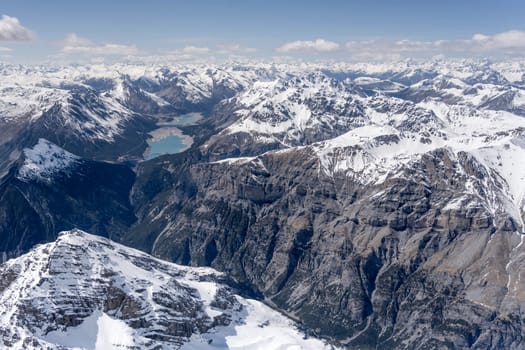 aerial landscape, from a glider plane, of Fraele valley and its lakes with Reit peak summit in foreground, shot from south in bright late spring light, Sondrio, Italy