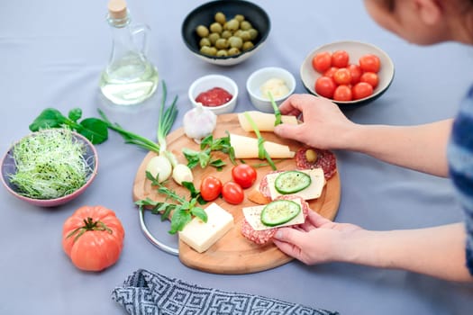 Preparing healthy snacks with fresh cheese and vegetables