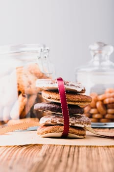 Gingerbread cookies, candies, sweets, dessert in jars on wooden table. Portrait orientation