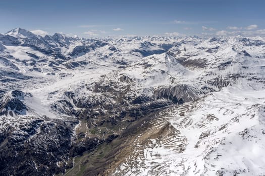 aerial landscape, from a glider plane, of Bernina pass road, shot from south in bright late spring light, Poschiavo, Switzerland