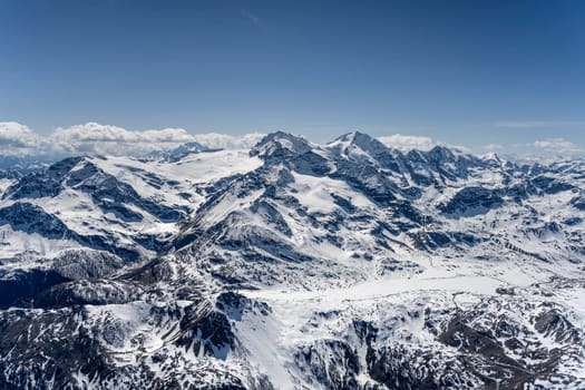 aerial landscape, from a glider plane, of Bianco iced lake at Bernina pass, shot from east in bright late spring light, Poschiavo, Switzerland