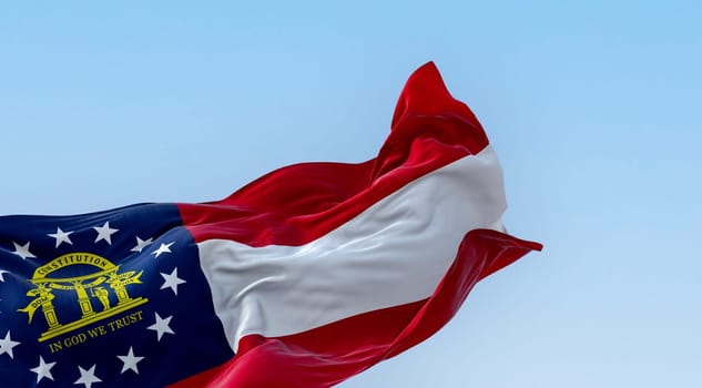 The state flag of Georgia waving in the wind on a clear day. Red, white, red stripes. Blue canton with 13 stars and coat of arms. 3d illustration render. Fluttering textile