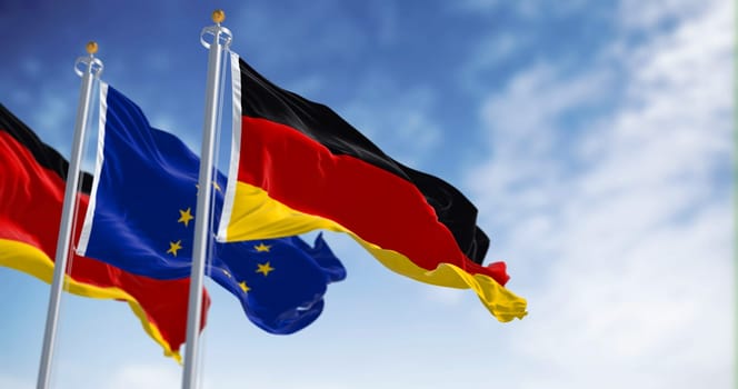 The flags of Germany and the European Union waving in the wind on a clear day. Germany became a member of the EU in january 1958. 3d illustration render. Fluttering fabric. Selective focus