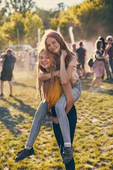 Portrait of happy smiling young girls with colorful paints on faces and clothes. Two friends spending time on holi color festival