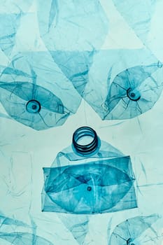 Empty plastic squashed bottles over blue background. Collecting plastic waste to recycling. Concept of plastic pollution and too many plastic waste. Copy space for text