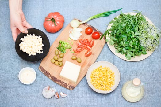 Preparing healthy snacks with fresh cheese and vegetables