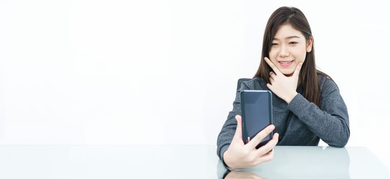 Close up woman long hair writing notebook and using mobile phone on white background